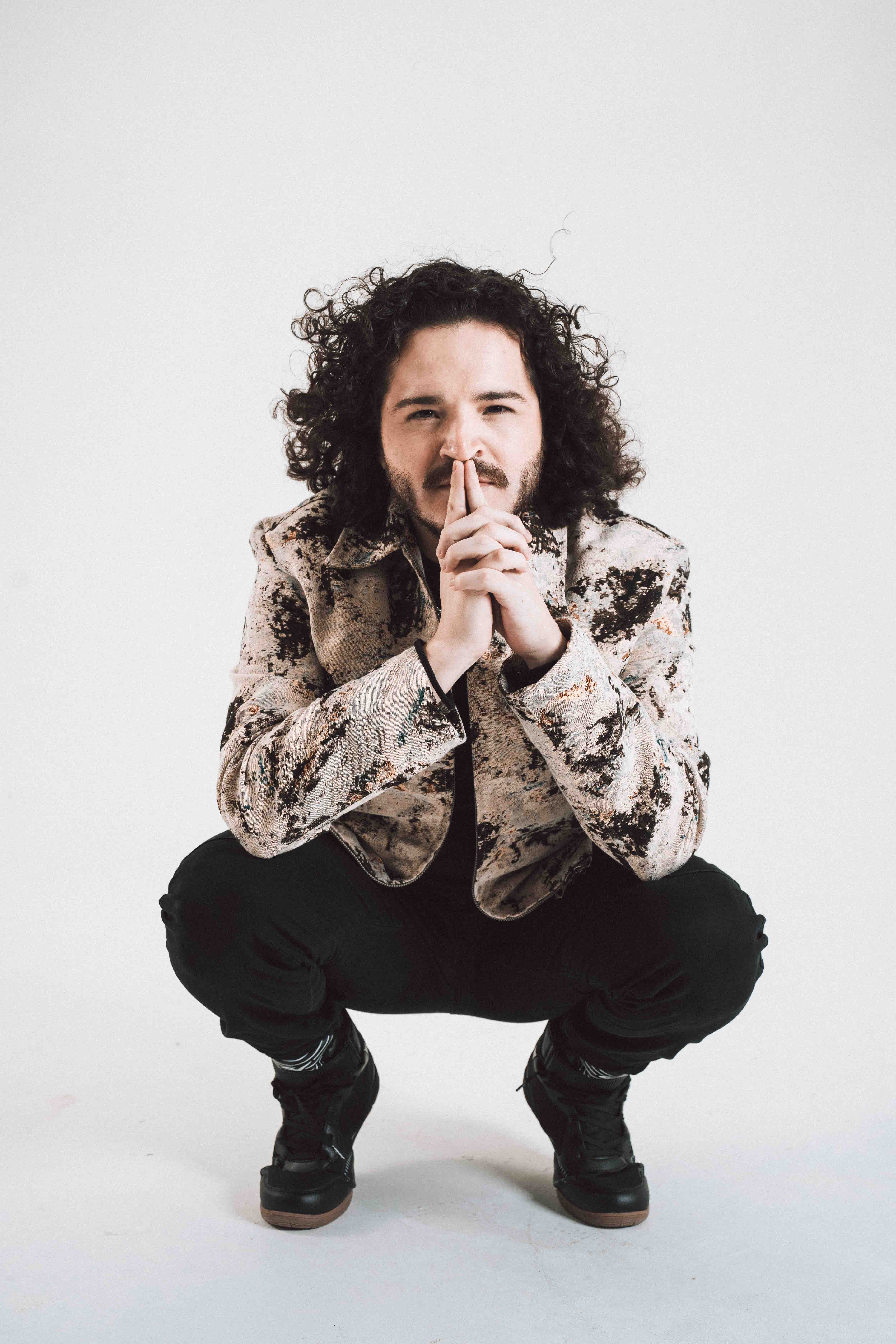 Foto del vocalista de la banda agachado y posando