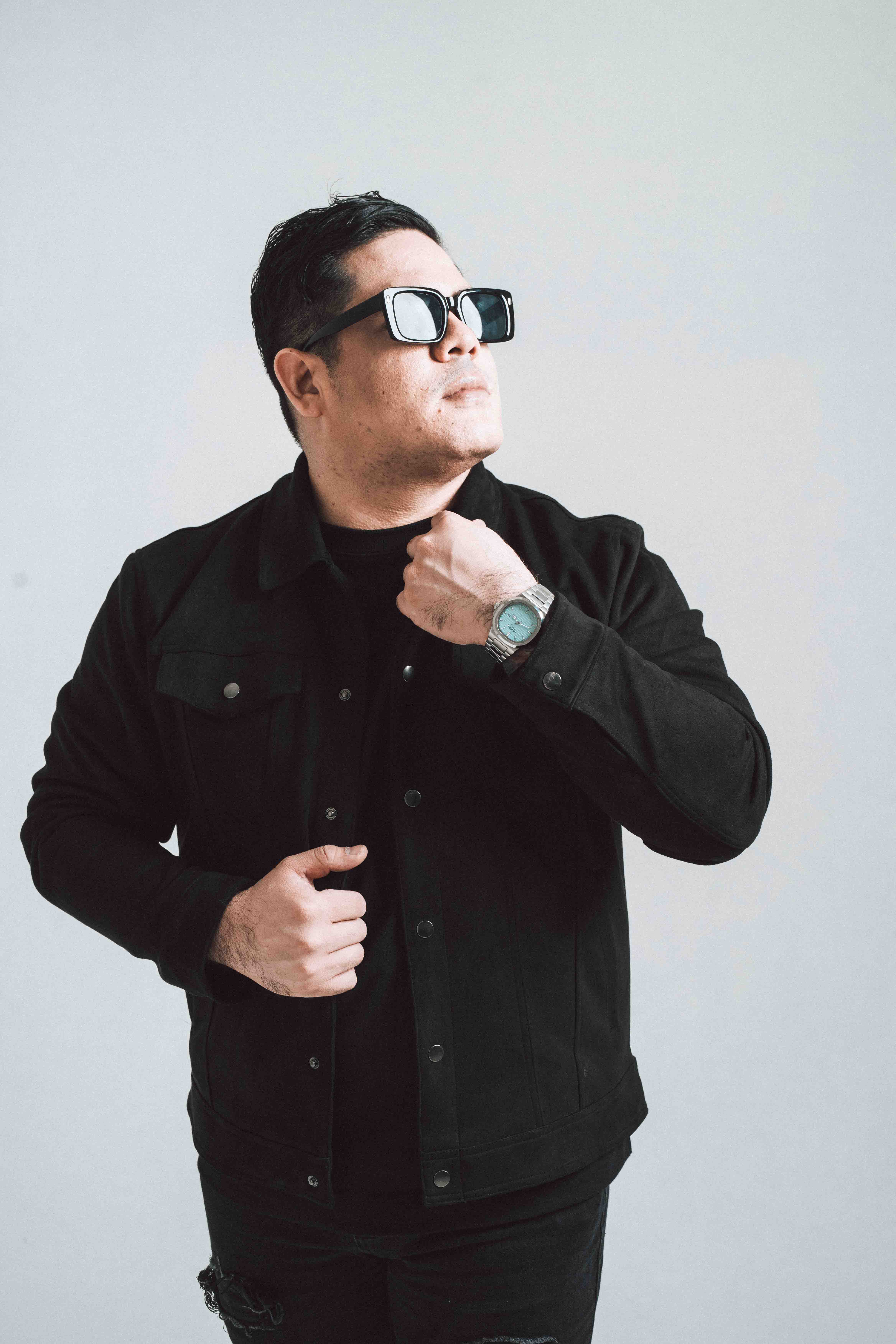 Foto del guitarrista de la banda ajustando su camisa en pose